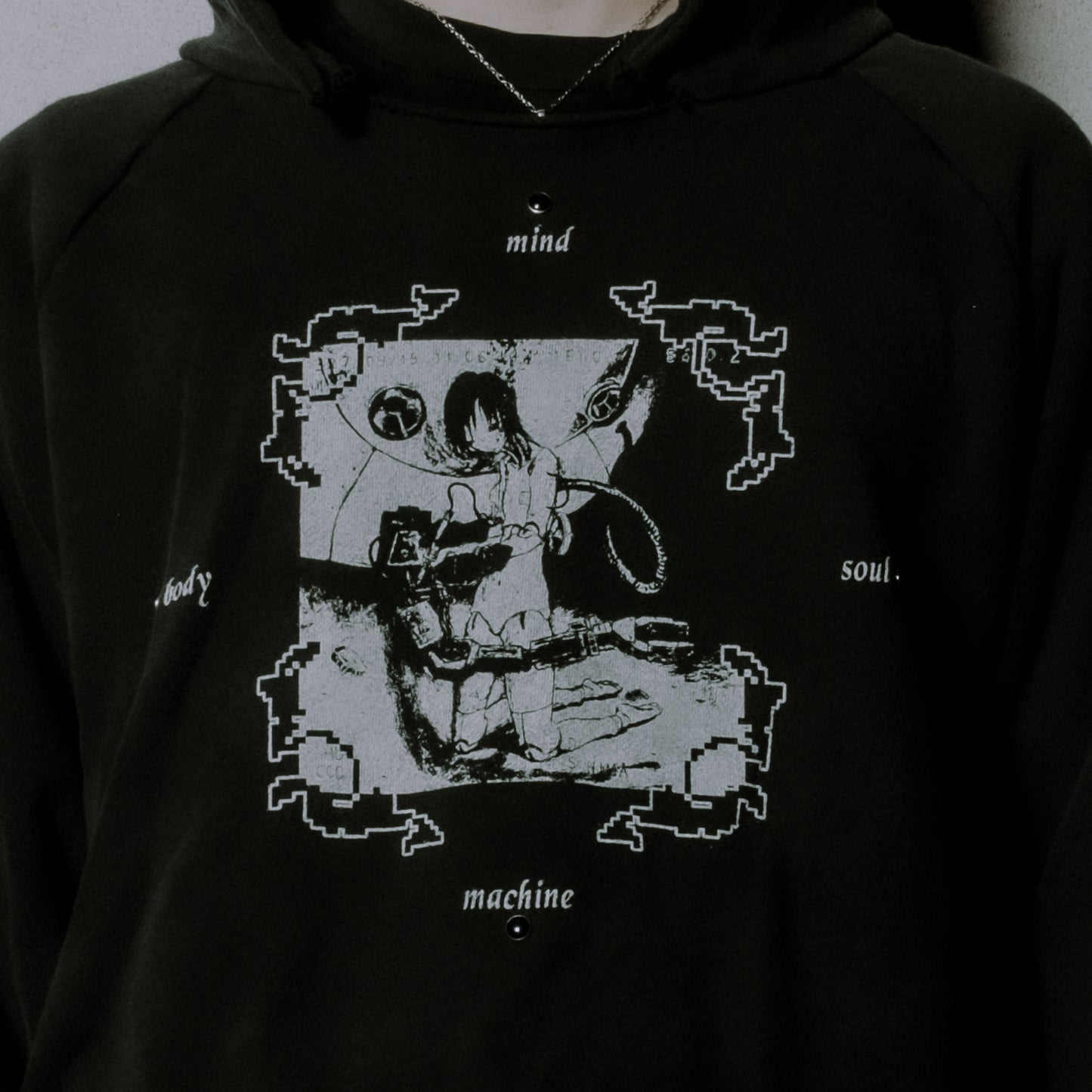 Black hoodie with a graphic design of a person sitting in a chair, labeled 'mind', 'body', 'soul', and 'machine'.